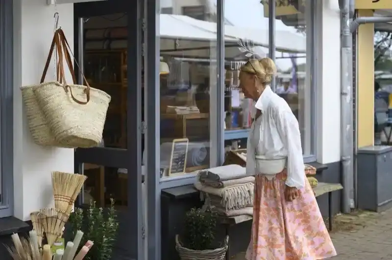 Vrouw loopt een kledingwinkel in
